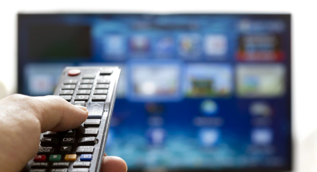 Smart tv and hand pressing remote control