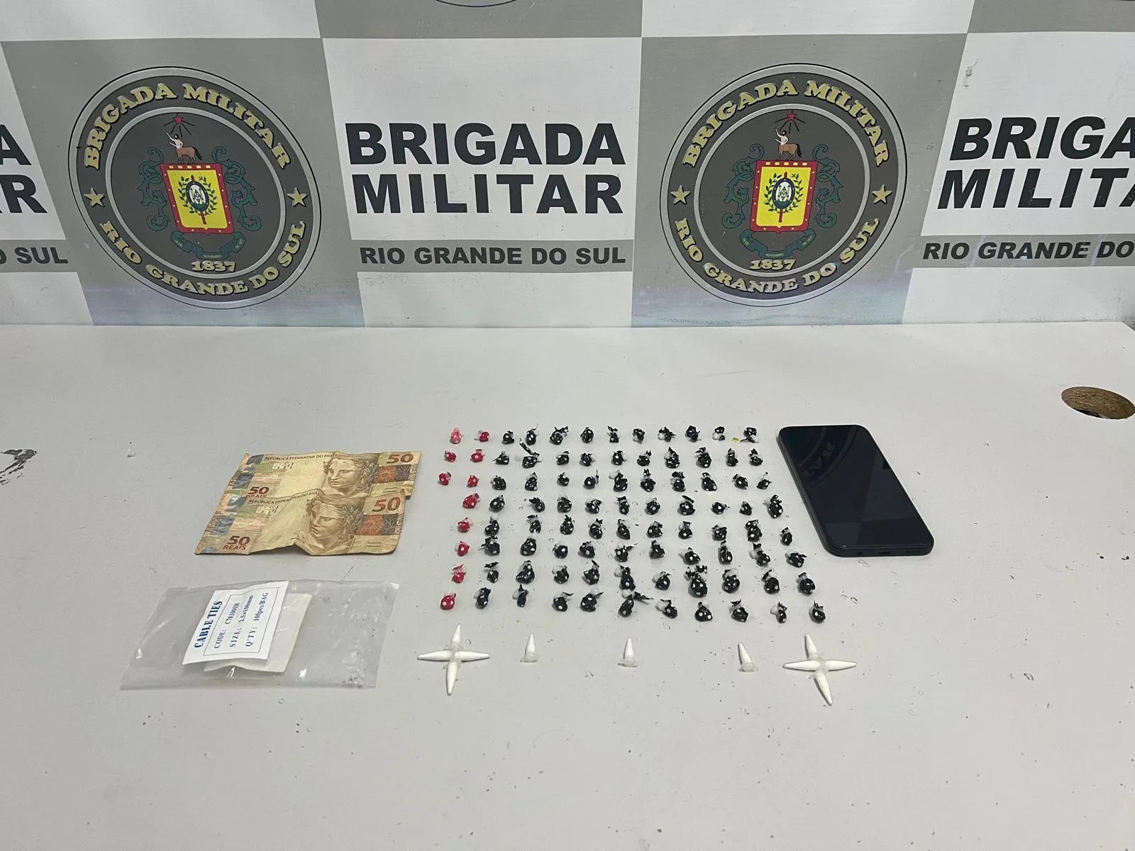 Foram apreendidos 91 pedras de crack, 11 buchas de cocaína, um celular, R$ 100,00 em espécie e embalagens para armazenamento das drogas.