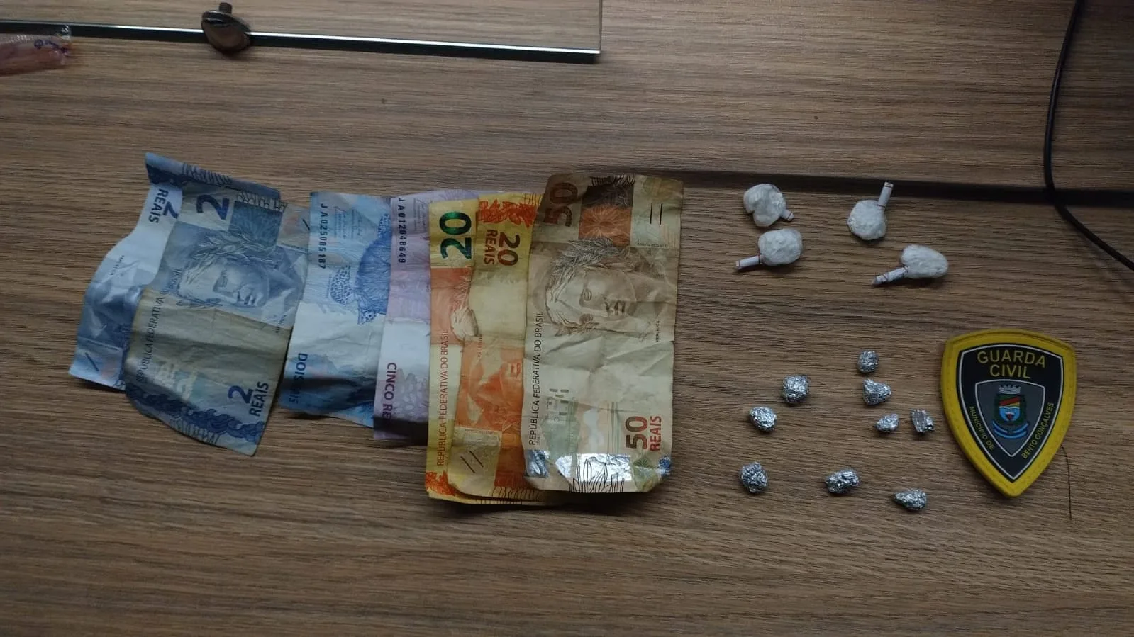 Com o foragido, foram encontradas quatro porções de cocaína, nove porções de crack e R$ 104 em dinheiro.