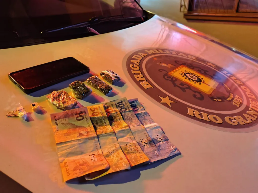 foram encontrados quatro porções de maconha, uma porção de cocaína, uma porção de crack, um celular e R$ 310, em moeda corrente. (Foto: 36º BPM)