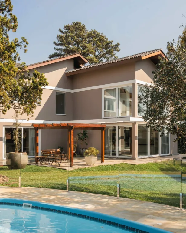 Casa moderna com piscina, gramado e pérgula de madeira. Arquitetura e paisagismo.