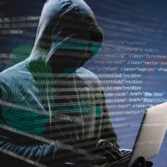 Hacker anônimo em frente ao código de computador.