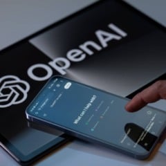 Smartphone exibindo a interface do ChatGPT com o logo da OpenAI em um tablet
