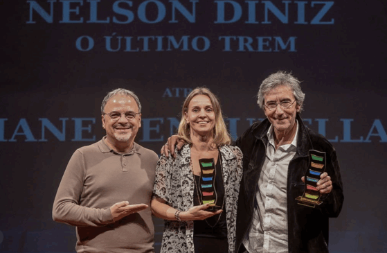 Foto: A proponente da produção Patrícia Larentis, representando Liane Venturella, e Nelson Diniz receberam o prêmio das mãos do ator Marcos Breda, homenageado da noite/Divulgação Festival de Cinema de Canoas