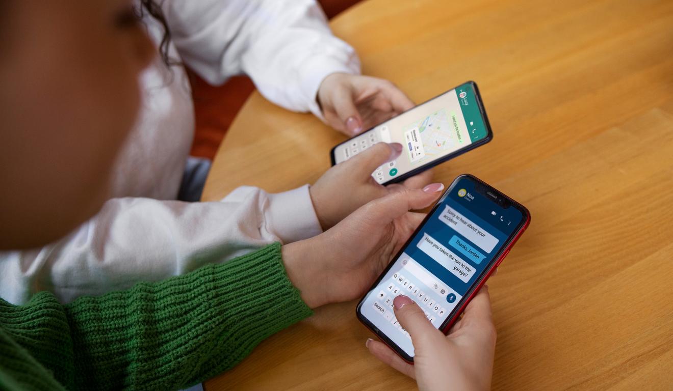 Duas pessoas usando seus smartphones para conversar por mensagens, com foco em detalhes da tela e teclado.