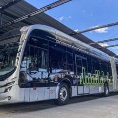 Ônibus elétrico moderno estacionado em estação, com detalhes em verde e cinza. Ônibus elétrico moderno estacionado em estação, com detalhes em verde e cinza.