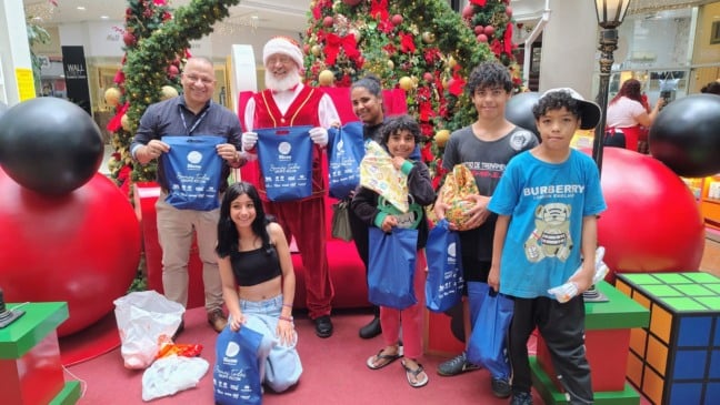 Uma família contemplada recebeu os presentes direto do Papai Noel no Shopping Bento.