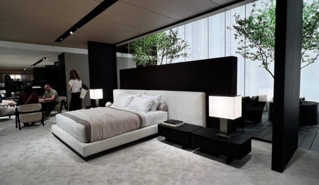 Quarto moderno com cama de design, cabeceira alta, e janela com vista para árvores.